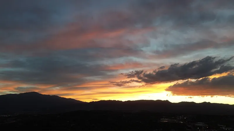 Orange and gold sunset over the silhouetted Front Range and Pikes Peak