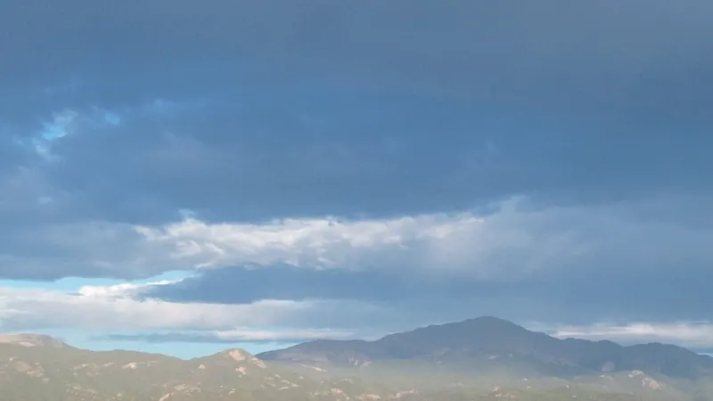 Storm clouds over Pikes Peak with evening light on the Garden of the Gods